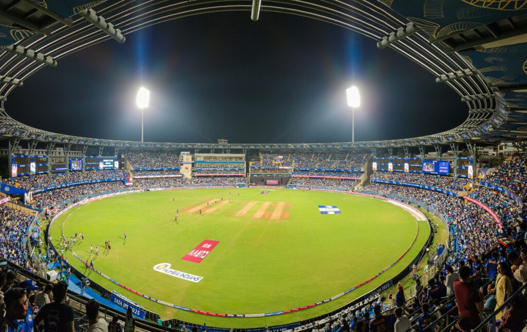 International cricket stadium full of spectators during a night match

