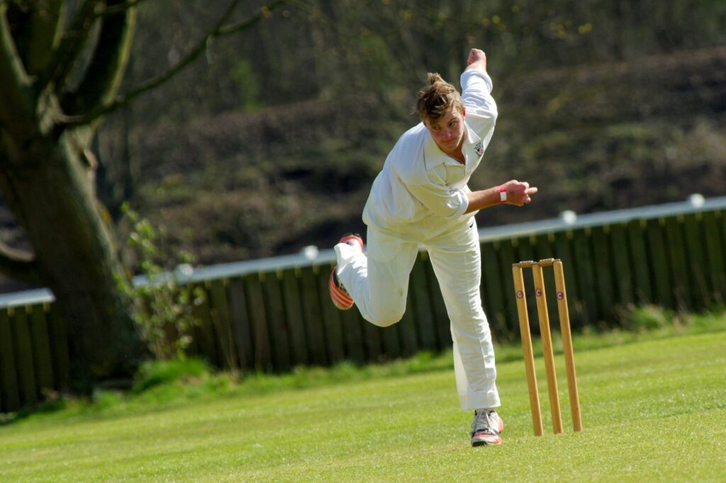 Fast bowler delivering a high-speed cricket ball during a match